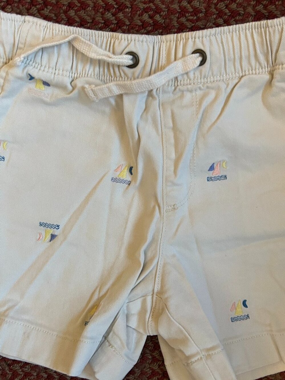 CREWCUTS Boys Cream-Colored Light Khaki Shorts with Sailboat and Waves Motif.